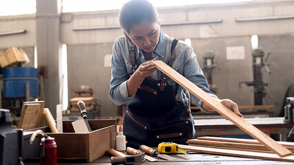 Carpenter working with equipment on wooden table in carpentry shop. woman works in a carpentry shop.