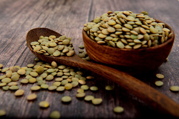 Organic green Lentils on a wooden bowl