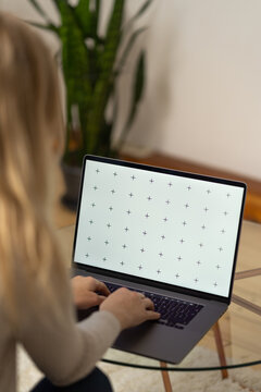 Woman working, laptop in a lap, glass table, browsing computerwith blank screen mock-up for your design at home office with blurry background with free space for custom text about business