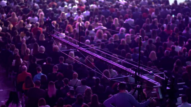 Professional operator operate telescopic crane with a video camera attached at business meeting event