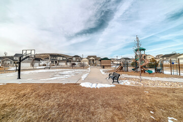 Fototapeta na wymiar Neighborhood landscape with views of homes basketball court and playground