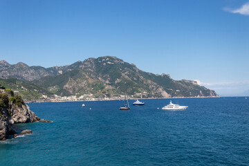 Fototapeta na wymiar Rocky coastline on Amalfi. Sea surface with rocks and a boat.