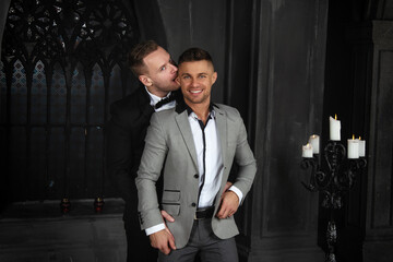 Young happy gay couple getting married in church. Love and romance. Handsome men in suits.