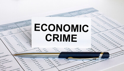 Text Economic Crime on white card with blue metal pen on financial table