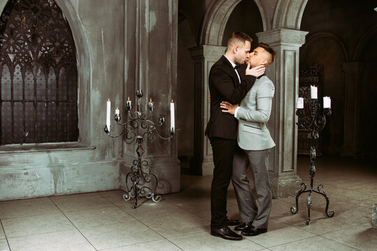 Young happy gay couple getting married in church. Love and romance. Handsome men in suits.