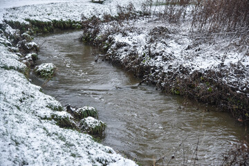 A brook bending round to the right in a sowy park in Uttoxeter England © Kirsty