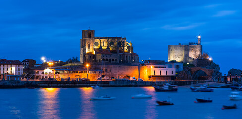 Obraz premium Castro Urdiales old town at dusk, with Santa Ana Church and Castillo Lighthouse, Cantabria, Spain, Europe