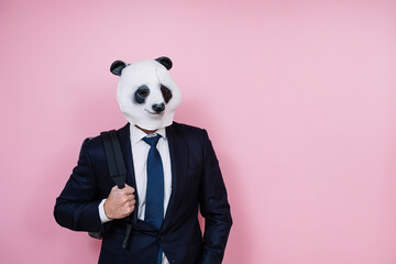 Man wearing panda mask against pink wall
