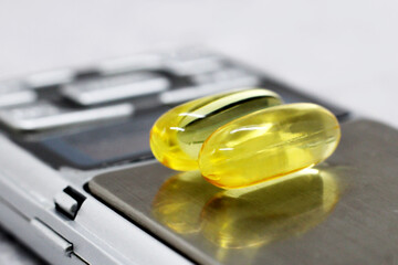 Two Omega 3 Capsules on the scale