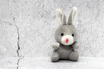 Toy soft rabbit on the background of plaster