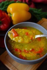 plate of red lentil soup with pepper and spices on a wooden table. vegetarian food