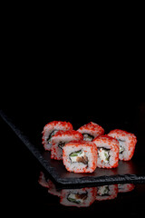 Philadelphia roll with salmon, cheese and cucumber on a black background with reflection. Sushi Philadelphia