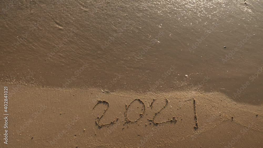 Wall mural Message Year 2020 replaced by 2021 written on beach sand background. Good bye 2020 hello to 2021 Lapping waves happy New Year coming concept - Wall murals