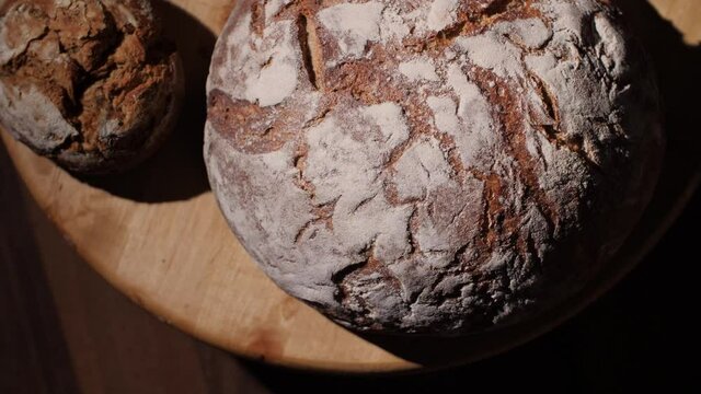 A delicious variety of home-baked, fresh and organic whole-grain bread loaves. Whole-wheat bread in a traditional German bakery. Tasty and healthy food. Rotating top-down view, macro, 4K.