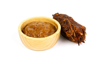Tamarind juice in bowl wooden isolated on white background. Tamarind sauce is a critical ingredient in many Thai foods.