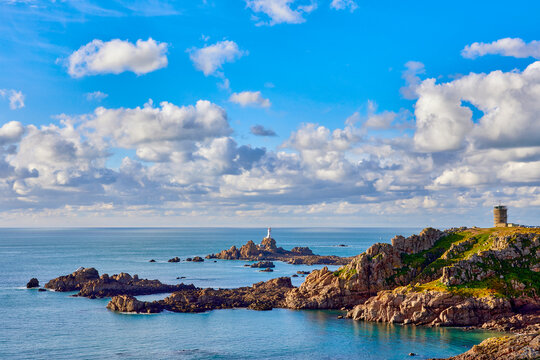 Image of corbiere lighthouse with WW2 tower, coastline and calm sea. Jersey, Channel Islands