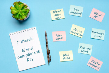 Happy World Compliment Day. Office desk with plant, notebook, pen and paper slips with compliments...