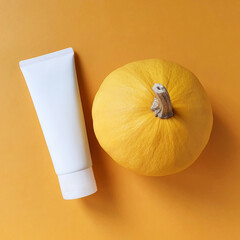 Unbranded white bottle tube for branding and label and yellow pumpkin on yellow background. Natural...
