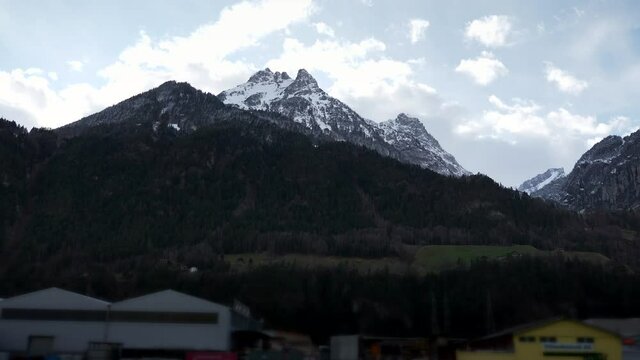 Hoch Geissberg - Scenic Snow capped Mountain Peak. Side View out of Car Window. Swiss Alps. Switzerland Europe. Slow motion