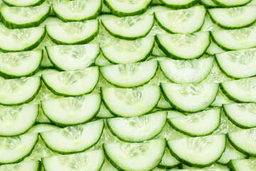 Fresh green slices of cucumber as background.