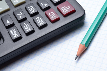 calculator, notebook and pencil lie together. close-up.