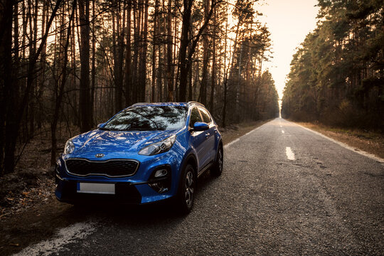 Kyiv, Ukraine - 26.03.2020 Blue Kia Sportage in the forest at sunset time