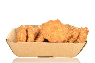 Several delicious torchetti cookies with oatmeal in a paper box, close up, isolated on white.