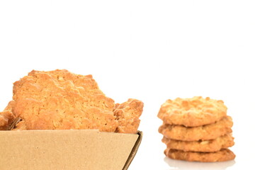 Several delicious torchetti cookies with oatmeal in a paper box, close up, isolated on white.