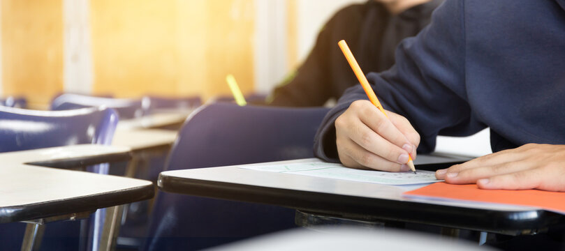 high school,university student study.hands holding pencil writing paper answer sheet.sitting lecture chair taking final exam attending in examination classroom.concept scholarship for education abroad