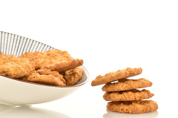 Several delicious torchetti cookies with oatmeal in a ceramic plate, close-up, isolated on white.