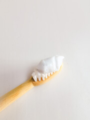 Micro plastic particles in a smear of toothpaste on a wooden toothbrush.