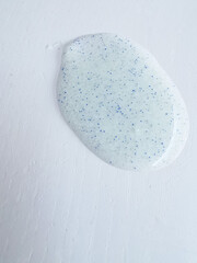 Micro plastic particles in a face scrub on a white background.