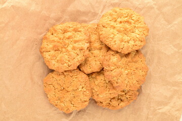 Two sweet torchetti cookies with oatmeal, close-up, on brown paper.