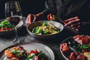 woman eating healthy salad from bowl sitting in cafe