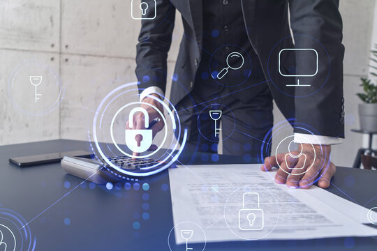 A businessman computing probability of risks in cyber security protection using calculator. Padlock Hologram icons over the working desk. Formal wear.