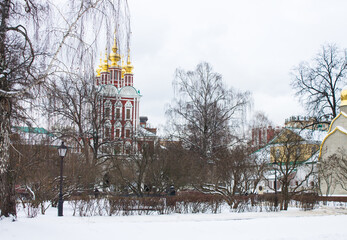Moscow, Russia-January, 3, 2021: historical architecture of the Novodevichy Monastery and white snow and bare trees on a cloudy winter day