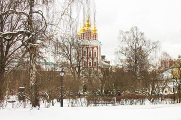 Moscow, Russia-January, 3, 2021: historical architecture of the Novodevichy Monastery and white snow and bare trees on a cloudy winter day