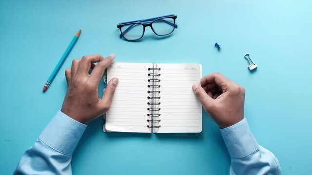 top view of man's hand turning a pager of a diary 