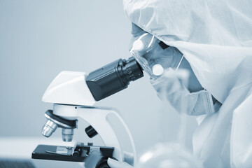 Laboratory research. Team work Scientists study data and evaluating microscope success. they are doing research with dropper chemical testing life science and find vaccine for covid 19