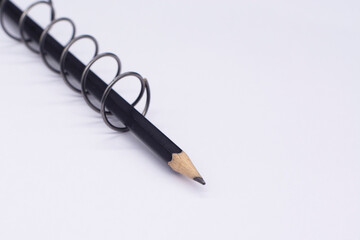 black pencil in a metal spiral on a white background