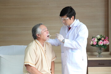 Male doctor checking a patient's throat in hospital background