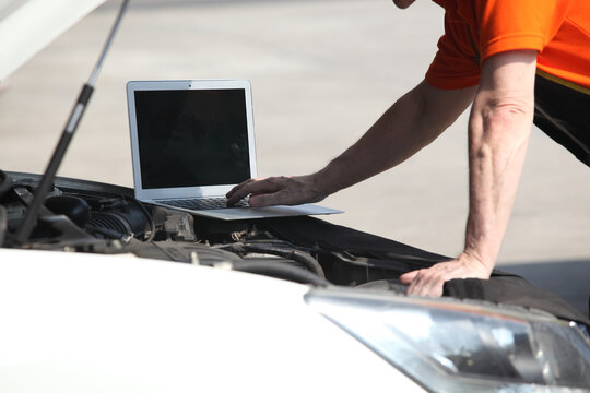 car mechanic use notebook computers to check engine and service maintenance of industrial to engine repair.In  transport automobile automotive