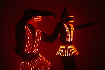 Two sexy disco dancers move in UV costumes. Parties and dances.