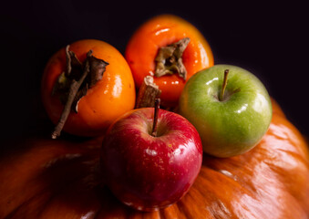 Winter fruits pumpkin red green apple black background