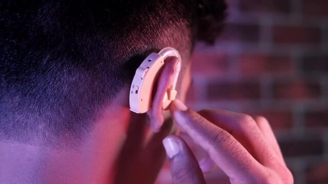 Hearing aid concept, a young man with hearing problems.
