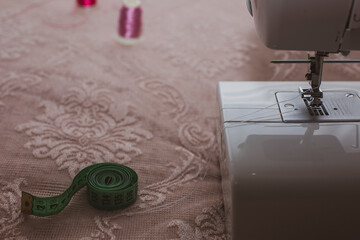 Fototapeta na wymiar sewing machine magenta background and tape measure
