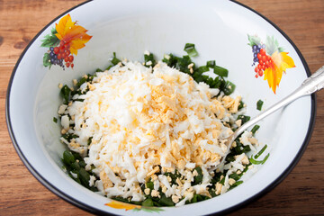 Green onions and boiled egg in an enamel bowl
