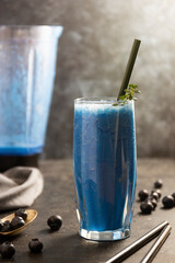 Blue smoothie with fresh banana, blueberry and spirulina powder. Healthy detox fruit smoothie drink glass