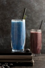 Smoothie glasses with spirulina powder. Fresh banana, blueberry healthy detox drinks.