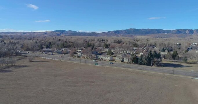 Fort Collins Colorado drone flight facing the rocky mountains on a blue sky and hazy warm morning in December 2020 during the pandemic.